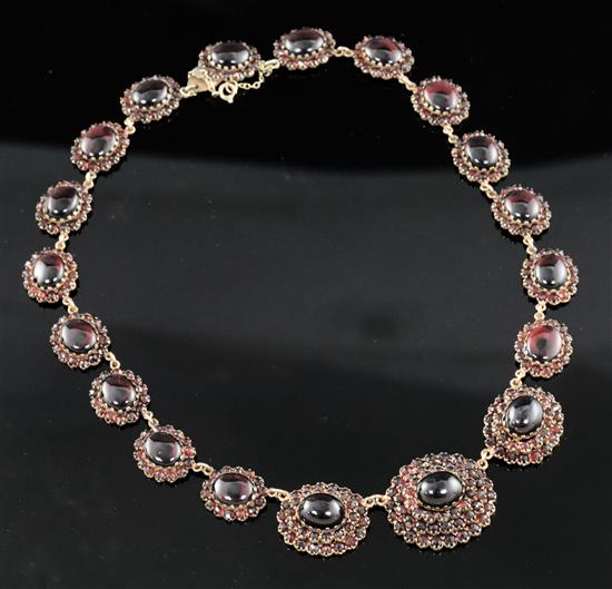 A late Victorian gold, cabochon and shaped cut garnet graduated oval link necklace, with safety chain, gross 63.1 grams.